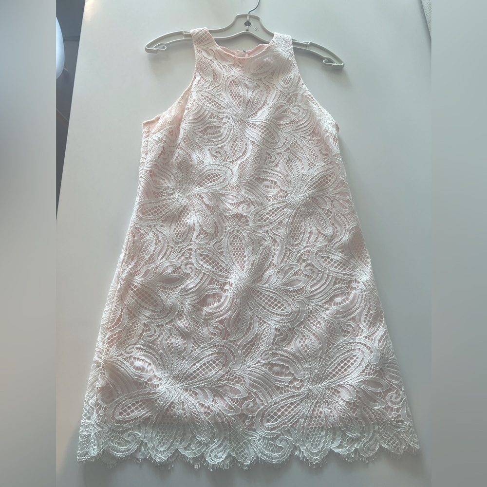 Off-white lace dress with pink lining.